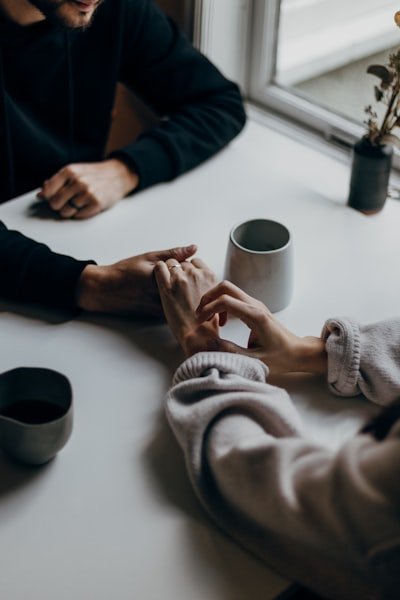 Couple holding hands at table
